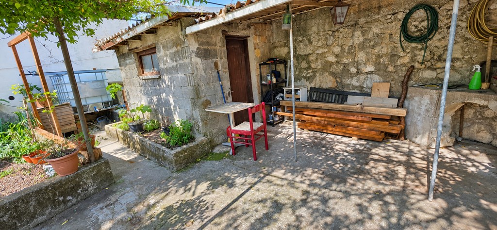 Steinhaus im Garten mit Tisch und Stühlen