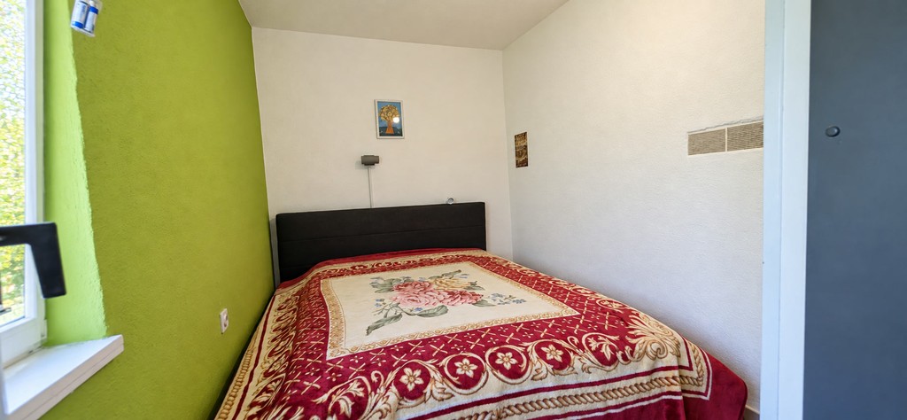 Schlafzimmer mit Bett und Fenster