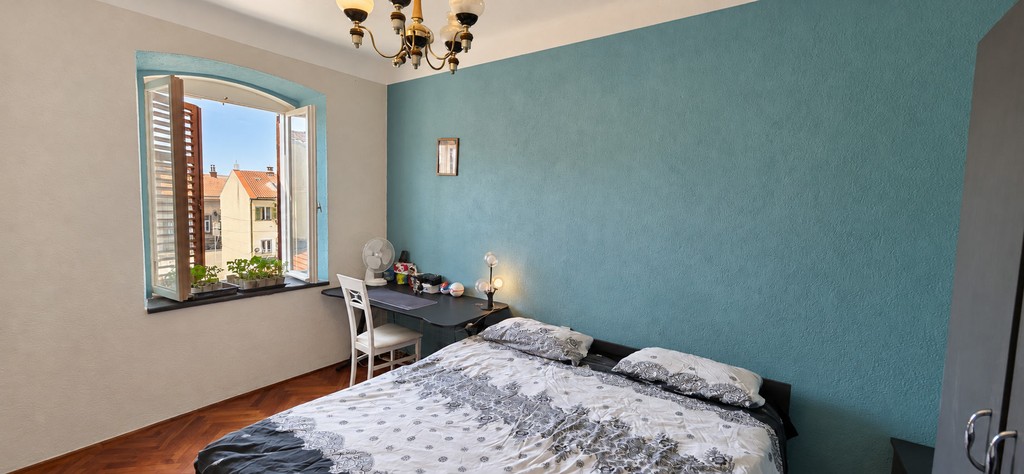 Schlafzimmer mit Doppelbett und Fensterläden