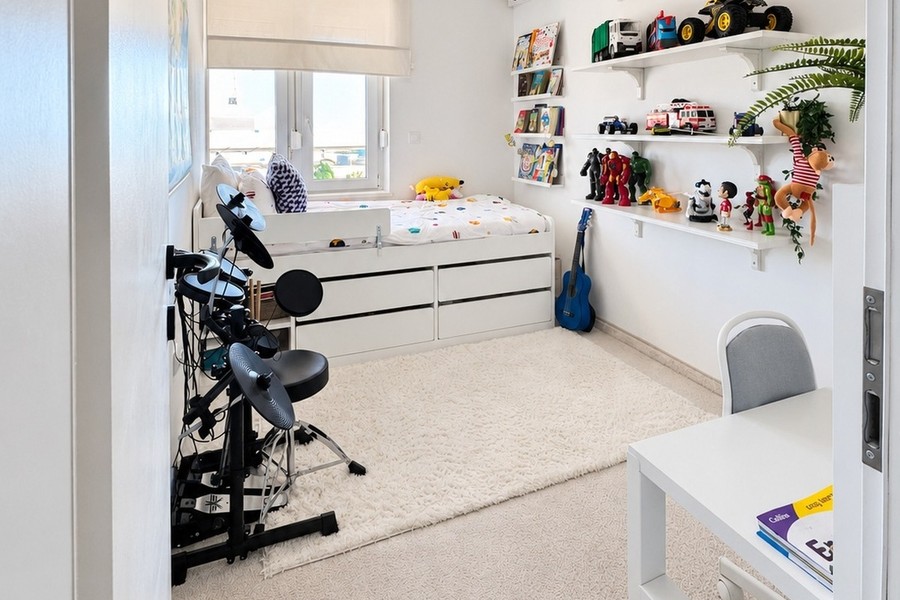 Kinderzimmer mit Bett, Regalen und Schreibtisch