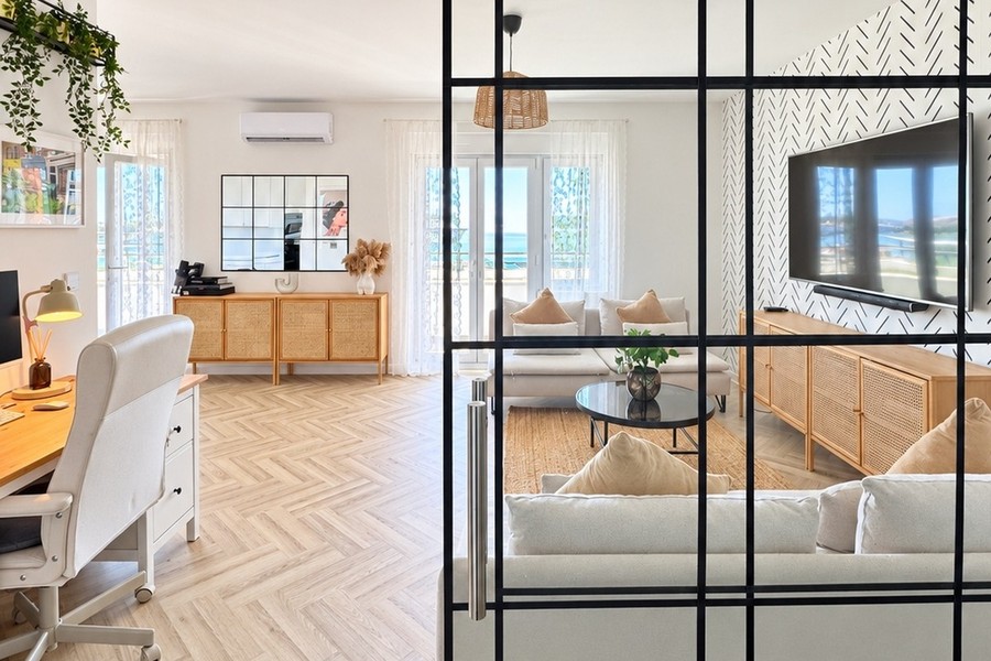 Arbeitsplatz mit Schreibtisch und Glaswand zum Wohnzimmer