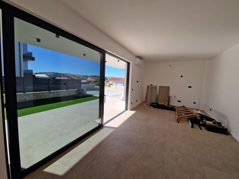 Wohnzimmer mit Glasfront und Blick in den Garten