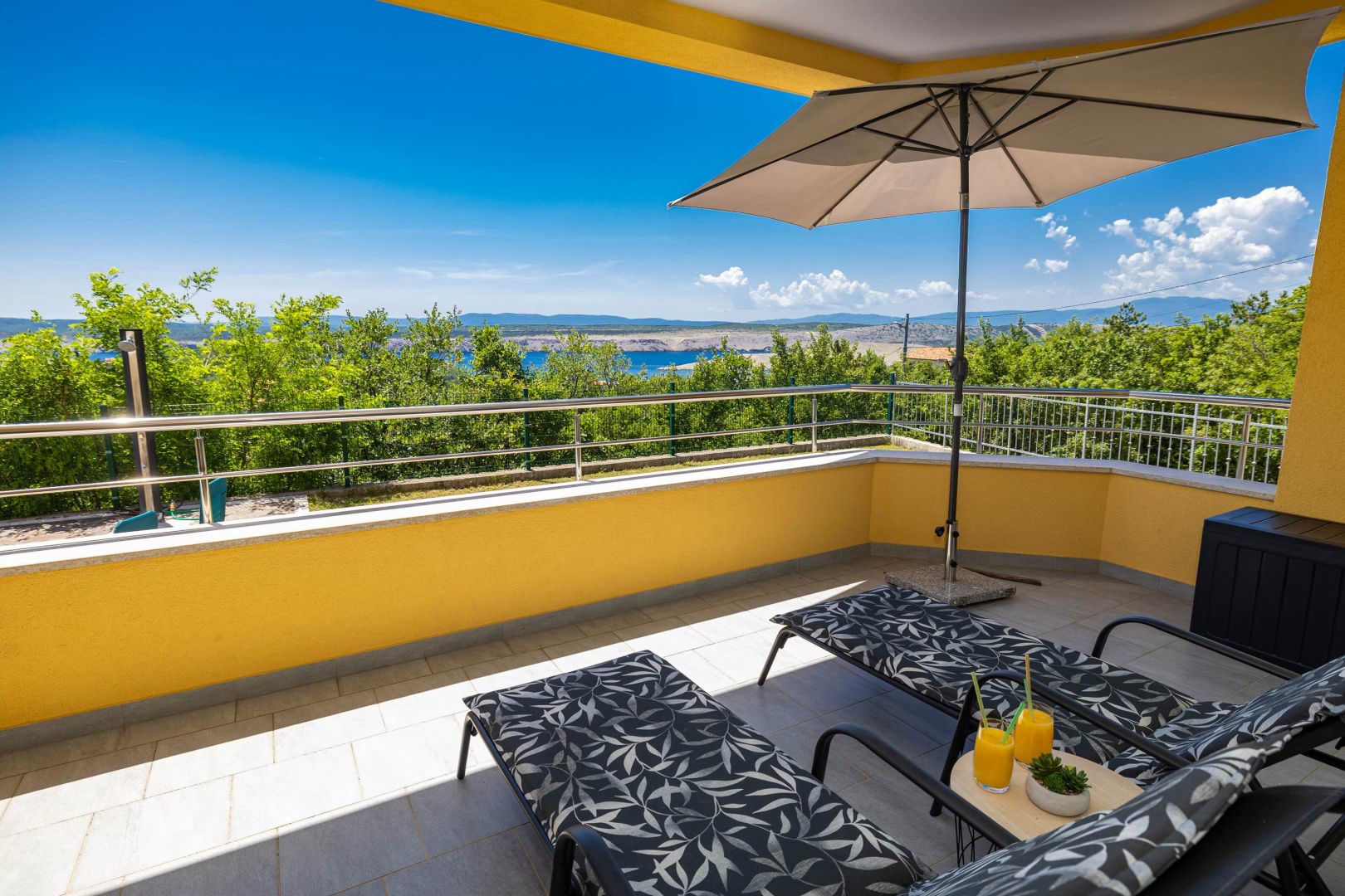Loggia mit Sonnenschirm und Meerblick