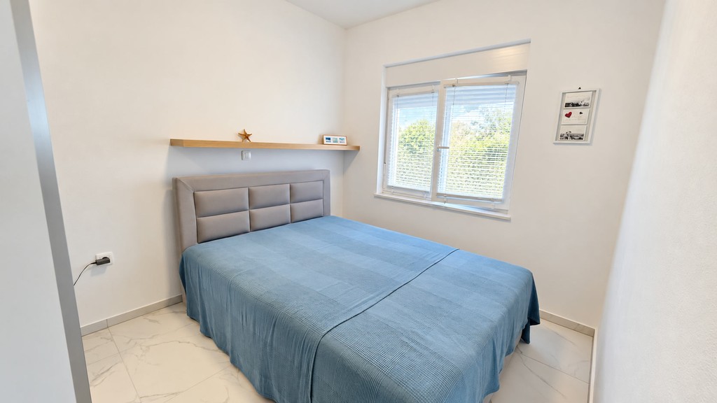 Schlafzimmer mit Wandablage und Fenster