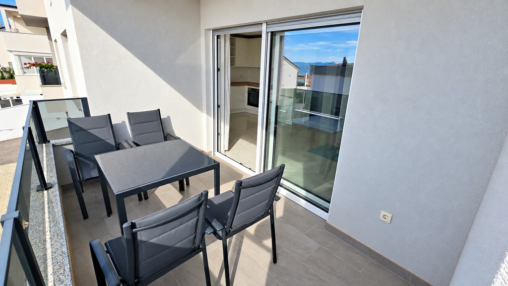 Überdachte Loggia mit Esstisch und Schiebetür