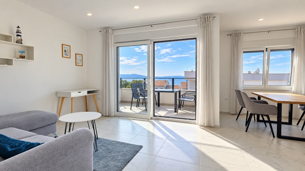 Wohnzimmer mit Ecksofa und Zugang zur Loggia