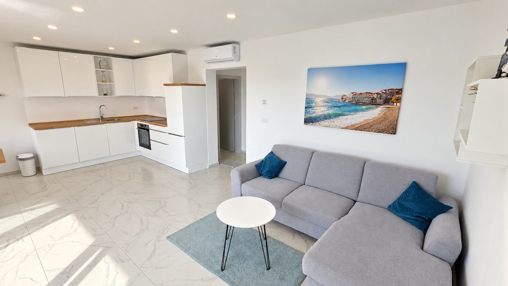 Wohnzimmer mit Sofa und offener Küche