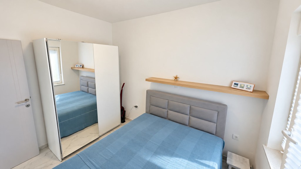 Schlafzimmer mit Spiegelschrank und Doppelbett