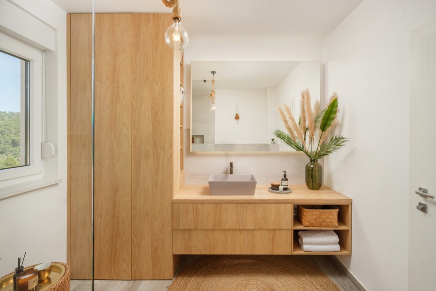 Badezimmer mit Waschtisch aus Holz und Spiegel