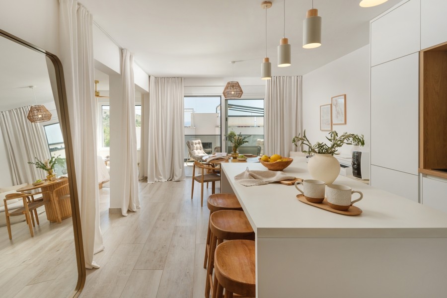 Offene Küche mit Barhockern und Blick zur Terrasse