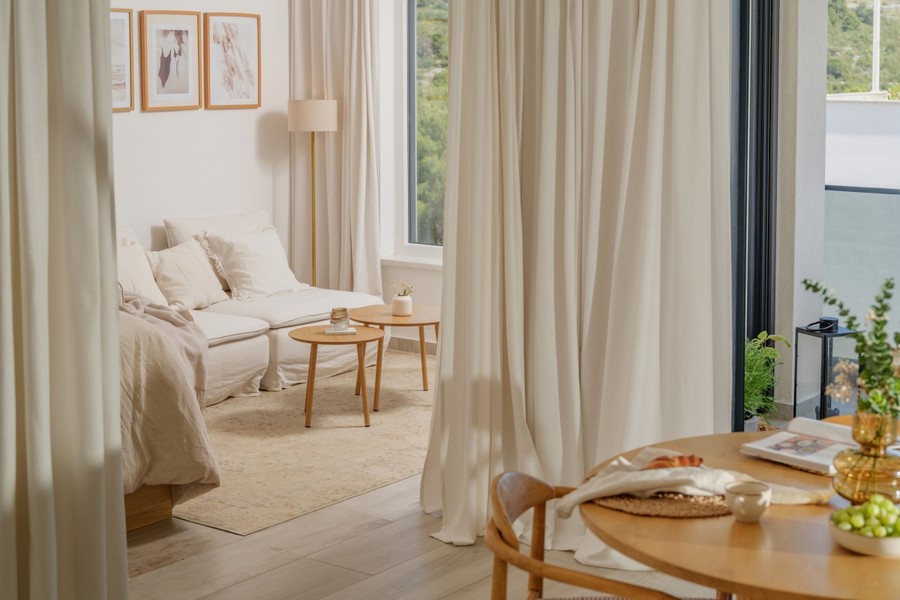 Wohnbereich mit Sofa, Vorhängen und Couchtisch