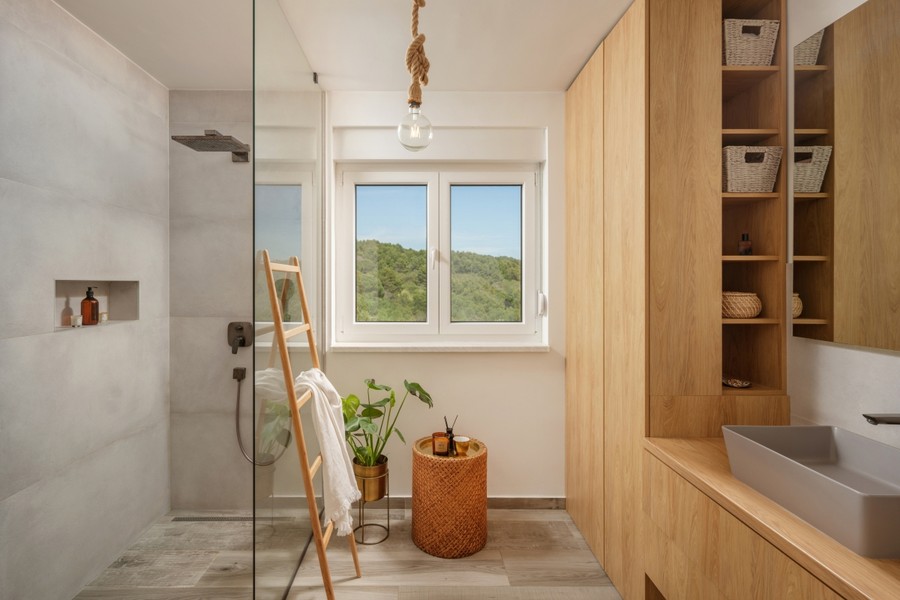 Badezimmer mit Dusche und Regal aus Holz
