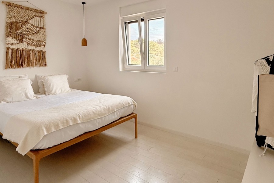Zweites Schlafzimmer mit Holzbett und Fenster