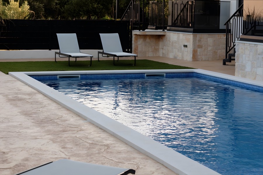 Swimmingpool mit Rasen und Sonnenliegen